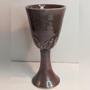 A handmade terracotta wine goblet or communion chalice with Sculpted Faces.